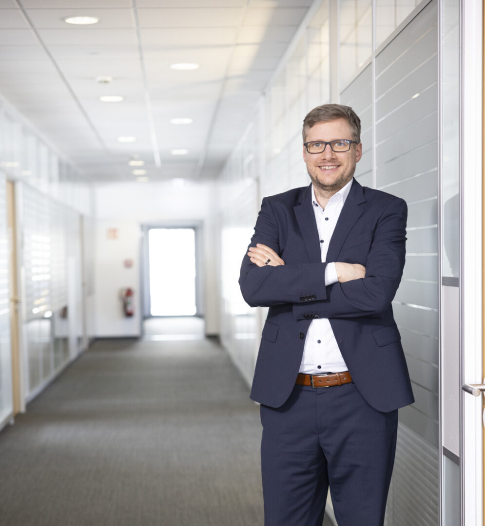 Peter Schuster im Anzug im Büro